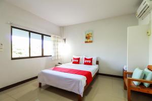 1 dormitorio con 1 cama grande con almohadas rojas en OYO 421 Dnk Baan Suan, en Lamphun