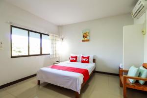 1 dormitorio con 1 cama grande con almohadas rojas en OYO 421 Dnk Baan Suan en Lamphun