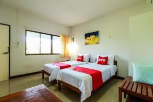 1 dormitorio con 2 camas con sábanas rojas y blancas en OYO 421 Dnk Baan Suan en Lamphun