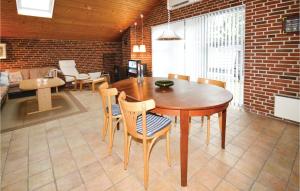 a dining room with a wooden table and chairs at Three-Bedroom Holiday Home In Rodby in Rødby