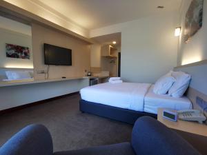 Sungai KechilSERDANG LAKE VIEW RESORT的一间配有床和平板电视的酒店房间