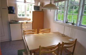 a kitchen with a wooden table and chairs in a room at Stunning Apartment In Allinge With Wifi in Allinge