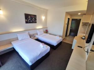 Sungai KechilSERDANG LAKE VIEW RESORT的一间有两张床和一台平板电视的酒店房间 更多13张照片