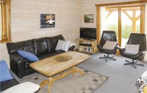 een woonkamer met een leren bank en 2 stoelen bij Gorgeous Home In Hesselager With Kitchen in Hesselager