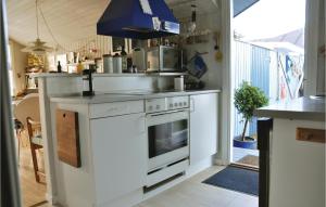 オテルプにあるCozy Home In Otterup With Wifiのキッチン(白いコンロ、シンク付)