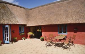 a red house with a table and chairs in front of it at Apartment Norre Nebel With Patio I in Stavsø