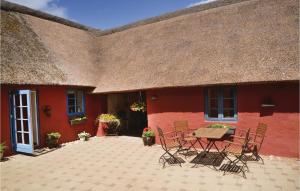 a red house with a table and chairs in front of it at Awesome Apartment In Nrre Nebel With 1 Bedrooms And Wifi in Stavsø