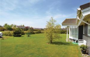 a yard next to a house with a green lawn at Holiday Home Elsdyrstien Ca Dnmk in Marielyst
