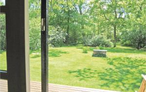 a view of a yard with a bench through a window at Holiday Home Sommerlystvej Gilleleje X in Gilleleje