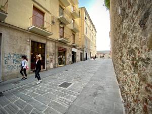 two women walking down a street in a city at DIMORA SARZANO ACQUARIO - GENOVABNB it in Genoa