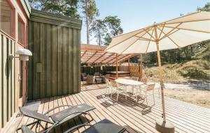 a wooden deck with a table and an umbrella at Holiday Home Nexø 14 in Vester Sømarken