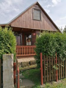 una casa de madera con una valla delante en Chaloupka v Českém ráji, en Rytířova Lhota