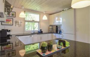 Una cocina con gabinetes blancos y encimera. en Three-Bedroom Holiday Home In Juelsminde, en Juelsminde