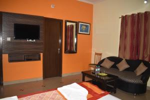 a living room with a couch and a television at Sakura House in Bodh Gaya