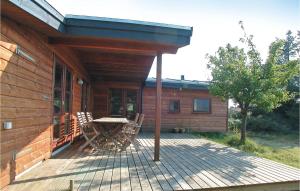a wooden deck with a table and chairs on a house at Holiday Home Nybyvej Fanø Vi in Fanø