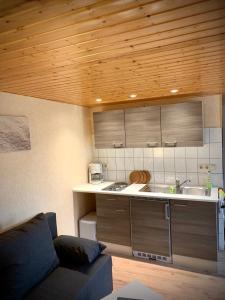 - une cuisine avec un canapé et un comptoir dans l'établissement Bungalow zur Kühlung, à Kühlungsborn