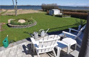 un patio con sillas blancas, una mesa y un patio en 3 Bedroom Stunning Apartment In Sydals, en Kegnæshøj