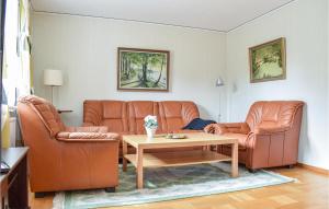 a living room with two leather couches and a table at 3 Bedroom Lovely Home In Orrefors in Orrefors