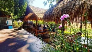 una piccola capanna con un tetto di paglia e un fiore di Mapping Hostel a Chiang Mai
