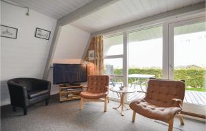 sala de estar con 2 sillas y TV en Stunning Home In Knebel With 3 Bedrooms, Outdoor Swimming Pool And Wifi, en Knebel