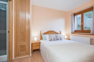 1 dormitorio con cama blanca y ventana en Apartamento Juclar en Soldeu