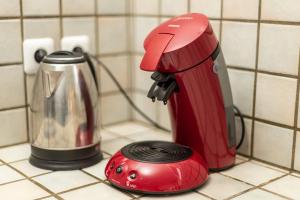 a red mixer sitting on a counter next to a toaster at La Brie à 15mn de Disneyland et Village Nature in Neufmoutiers-en-Brie