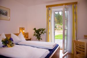 a bedroom with two beds and a sliding glass door at Ferienhof Rinnergut in Hinterstoder