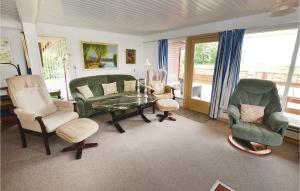 ein Wohnzimmer mit Stühlen, einem Tisch und einem Sofa in der Unterkunft Stunning Home In Egernsund With Kitchen in Egernsund