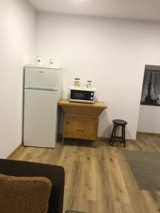 eine Küche mit einem Kühlschrank und einem Tisch mit einem Stuhl in der Unterkunft Casa Moinhos do Rio in Paredes