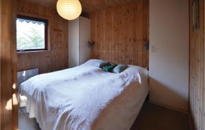 a bedroom with a white bed in a wooden wall at Gorgeous Home In Spttrup With Kitchen in Spottrup