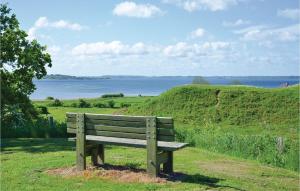 a wooden bench sitting on a hill overlooking the water at Three-Bedroom Holiday Home In Egernsund in Egernsund