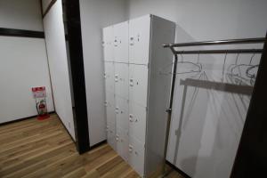 ein Umkleideraum mit weißen Schließfächern in einem Zimmer in der Unterkunft HOSTEL MICHIKUSA-YA in Fujikawaguchiko