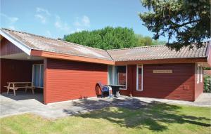 a red house with a picnic table in front of it at Three-Bedroom Holiday Home In Egernsund in Egernsund