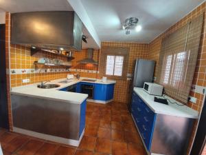 a kitchen with blue cabinets and a sink at Villa Solojog23 in Arriate