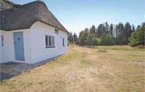 a small white building with a thatched roof at Holiday Home Nørre Nebel 21 in Nymindegab