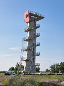 Una gran torre con un objeto rojo encima. en Zimmervermietung Cottbusser Ostsee, en Cottbus