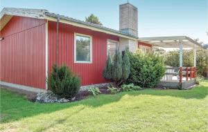 a red house with a porch and some bushes at 2 Bedroom Nice Home In Hejls in Hejls