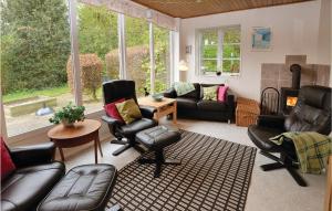 a living room with leather furniture and a fireplace at Three-Bedroom Holiday Home In Sydals in Ertebjerg Skov