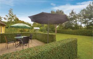 a patio with a table and an umbrella at 2 Bedroom Nice Home In Stege in Stege