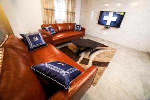 uma sala de estar com dois sofás de couro e uma televisão em Appart MRode Djidjole em Lomé