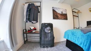 マーサー・ティドビルにあるBike Park Lodgeのベッドルーム1室(ベッド1台、テーブル、バッグ付)