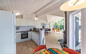 スラーエルセにあるBeautiful Home In Slagelse With 3 Bedrooms And Wifiの白いキャビネット付きのキッチン、オープンリビングルーム