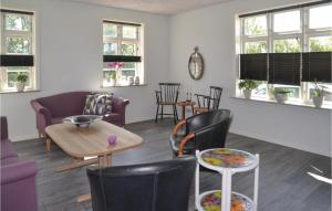 ein Wohnzimmer mit Stühlen, einem Tisch und Fenstern in der Unterkunft Gorgeous Home In Outrup With Kitchen in Vester Debel