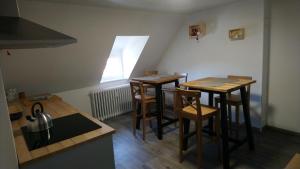 a kitchen with two tables and chairs in a room at RESTAURANT hébergement "Relais de la poste" in Masevaux