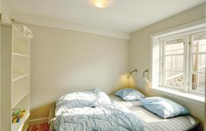 Un dormitorio con una cama con almohadas y una ventana. en Holiday Home Vang Hasle Iii, en Hasle