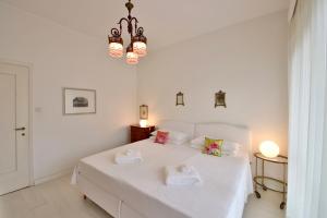 a white bedroom with a white bed with towels on it at Sofia by KlabHouse in Santa Margherita Ligure