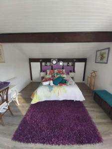 a bedroom with a large bed with a purple rug at Euskadi in Bidart