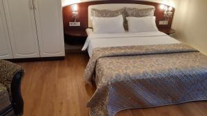 a hotel room with a large bed and a chair at Apartment nr. 8 in Odesa
