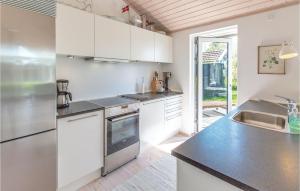 スラーエルセにあるAwesome Home In Slagelse With 3 Bedrooms And Wifiのキッチン(白いキャビネット、黒いカウンタートップ付)