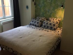 - une chambre avec un lit et des oreillers dans l'établissement LES LOGES D'ARSENE, à Aurillac